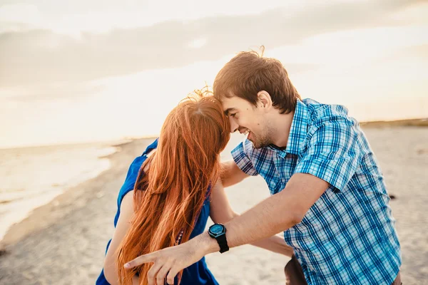 A young couple enjoys a mid summer late afternoon, on a wet san — Stockfoto