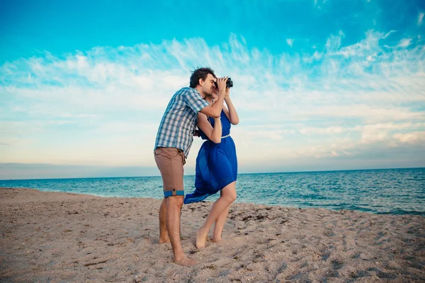 Un jeune couple profite d'un milieu d'été en fin d'après-midi, sur un san humide — Photo