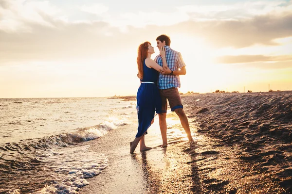 Um jovem casal desfruta de um verão no final da tarde, em um san molhado — Fotografia de Stock