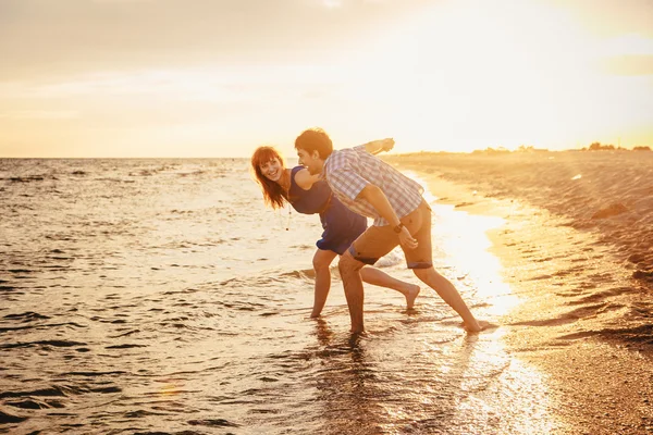 Una joven pareja disfruta de un verano a media tarde, en un san mojado — Foto de Stock