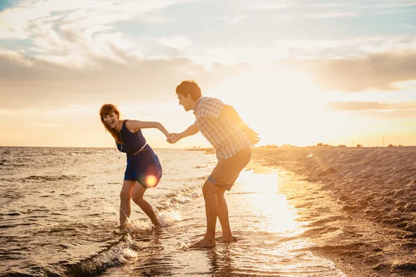 Um jovem casal desfruta de um verão no final da tarde, em um san molhado — Fotografia de Stock