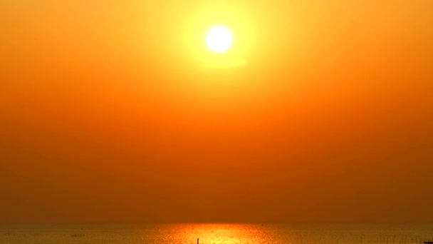 Pôr do sol no céu laranja e luz solar reflexão com pouco na superfície do mar — Vídeo de Stock