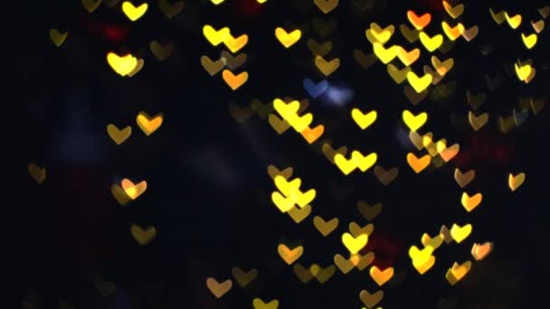 Размытые желто-оранжевые сердечки теплой формы на стене красивого ночного света — стоковое видео