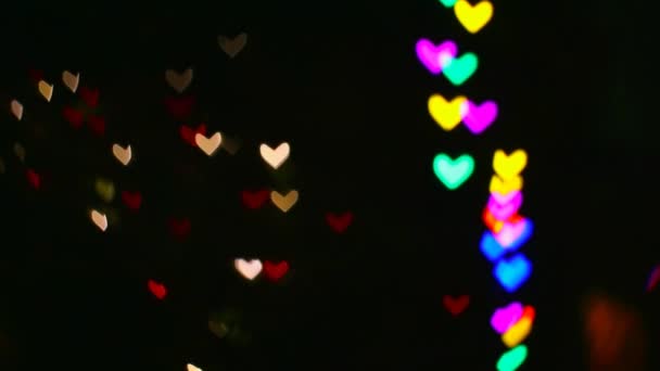 Rojo borroso cálidos corazones de forma panorámica en la pared hermosa forma de arco iris corazones luz nocturna en un buen día — Vídeo de stock