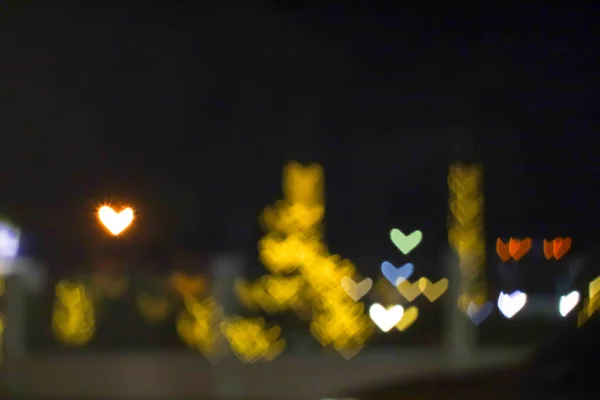 黄色的奶茶和模糊的心形爱情情人节五彩缤纷的夜晚街上的灯光 — 图库照片