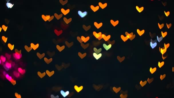 Розмиті червоні помаранчеві теплі форми серця блимають на дереві красиве нічне світло в саду — стокове відео