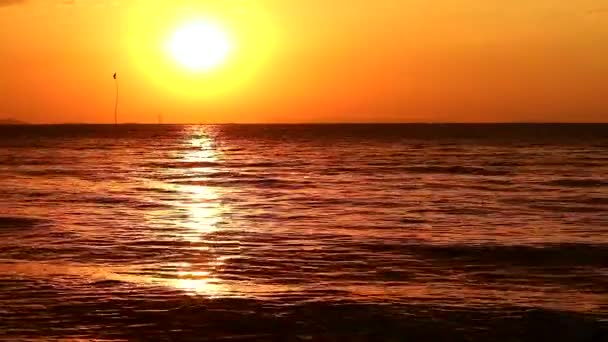 Ηλιοβασίλεμα στον ουρανό και αντανάκλαση του ήλιου με λίγο στη σκοτεινή επιφάνεια της θάλασσας — Αρχείο Βίντεο