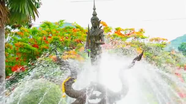 Phra Phirun riding a Naga with fountain and colorful frame tree flower background, He is god of naga and god of water and rain according to the beliefs of Hinduism, and he is a deity world of west — Stock Video