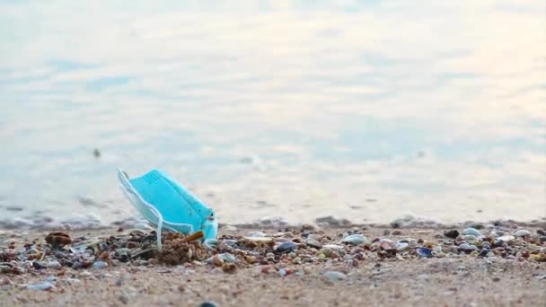 Použité masky jsou na pláži vyřazeny na písek, pojetí nebezpečného odpadu a rizika infekce — Stock video