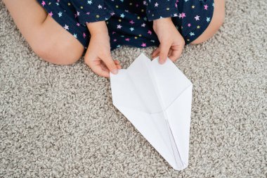 Küçük kız kağıttan uçak yapıyor. Yüksek kalite fotoğraf