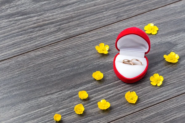 Proposta de casamento com anéis de ouro na caixa vermelha do coração no fundo de madeira — Fotografia de Stock