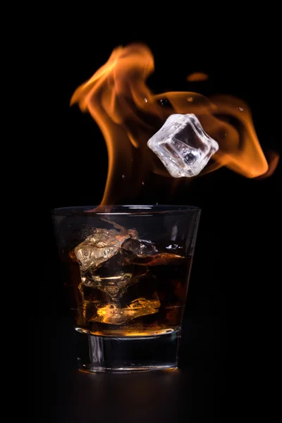 Koncepcja gorący napój z kostki lodu w szklance. Na czarnym tle. — Zdjęcie stockowe