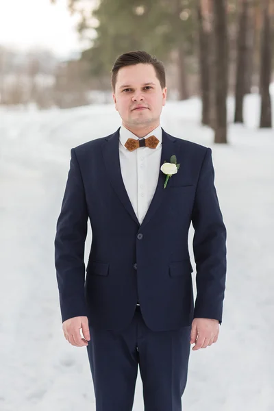 Portrait groom in the winter