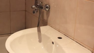 adam musluk altında ellerini yıkar