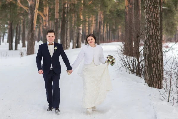 Couple newlyweds walking in a winter forest — Stock Photo, Image