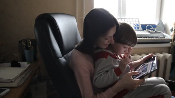 Moeder en zoon op zoek naar een tablet. — Stockvideo