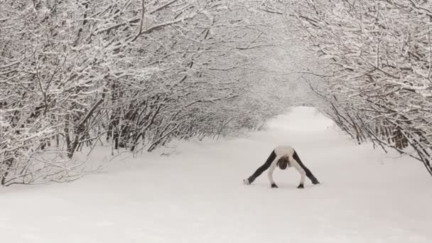 Ung kvinna gör stretching övningar under vintern — Stockvideo