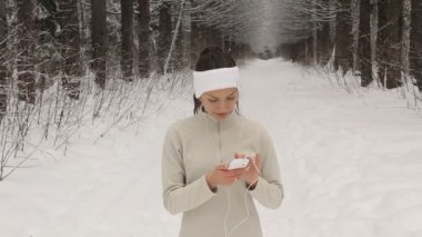Müzik ve dışarıda kışın koşu genç kadın
