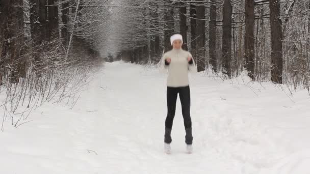 Молодая женщина делает упражнения на растяжку зимой — стоковое видео