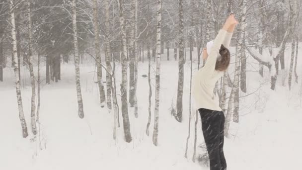 Νεαρή γυναίκα που κάνει το τέντωμα ασκήσεις κατά τη διάρκεια του χειμώνα κατάρτισης εκτός — Αρχείο Βίντεο