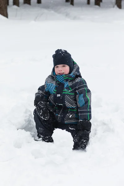 Παιδί απολαμβάνει το χειμώνα και παίζει με το χιόνι — Φωτογραφία Αρχείου