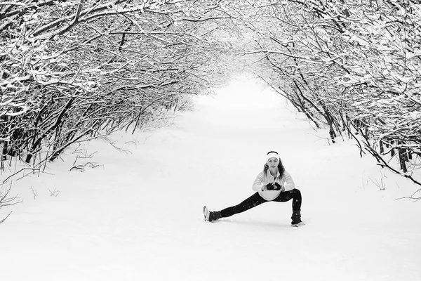 Jovem fazendo exercícios de alongamento durante o inverno — Fotografia de Stock