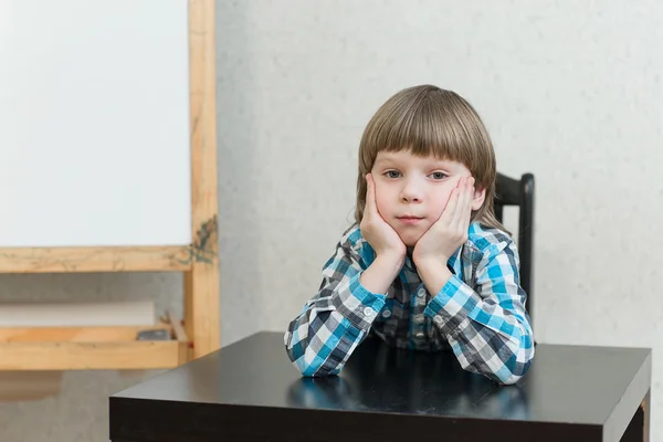 Boy sitting at home and look — Stock Photo, Image