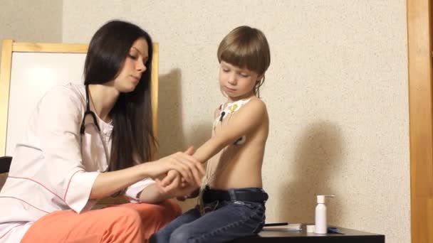 Žena kardiolog provádí příjem a zkoumat chlapce — Stock video
