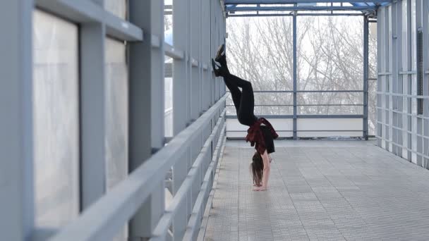 Sportowe kobieta robi gimnastyka, stojąc na ulicy w rękach — Wideo stockowe