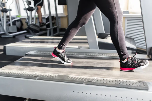 Sports woman is running on the treadmill — Stock Photo, Image