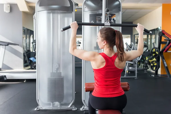 Mujer joven deportiva haciendo ejercicios en el gimnasio . —  Fotos de Stock