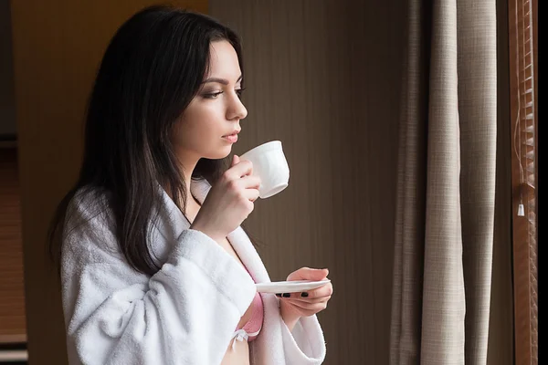Женщина в квартире держит чашку кофе — стоковое фото