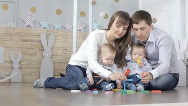 Familia con niños construyendo una casa de diseñador de madera — Vídeo de stock