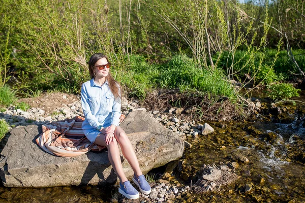 Kvinna sitter på stenen — Stockfoto