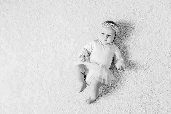 Bebê jaz no chão — Fotografia de Stock