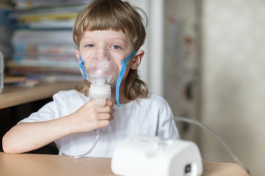 Çocuk bir maske buharı inhaler tutar