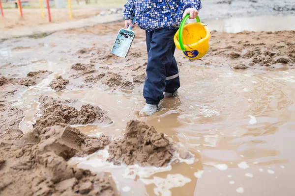 Niño jugando en un charco fangoso —  Fotos de Stock