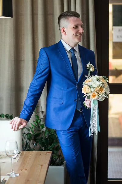 Bräutigam steht und hält Brautstrauß — Stockfoto