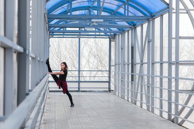 Spor kadının açık havada germe yapması