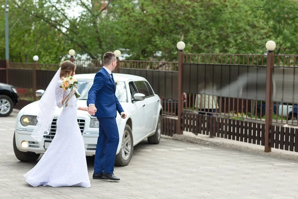 Groom and bride go to car — Stock Photo, Image