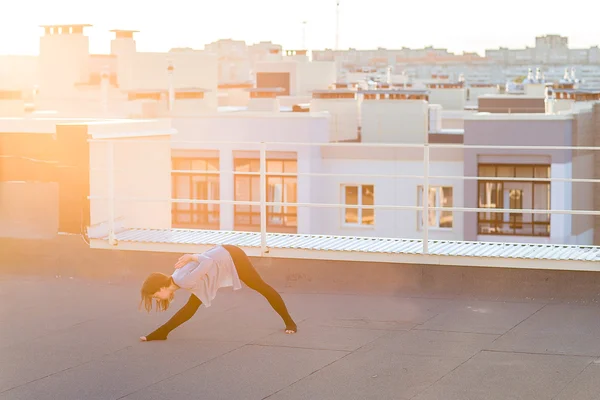 屋根の上のヨガを行う若い女性 — ストック写真