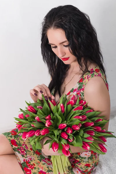 Vacker ung kvinna med en bukett blommor — Stockfoto