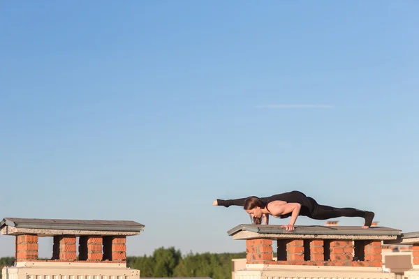 做瑜伽在屋顶上的年轻女子 — 图库照片