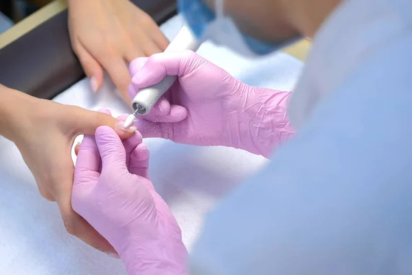 Mulher manicure remove polonês goma-laca usando máquina de manicure, mãos closeup. — Fotografia de Stock