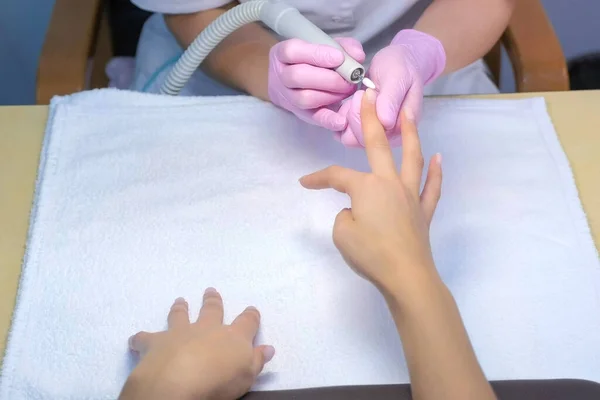 Mulher manicure remove polonês goma-laca usando máquina de manicure, mãos closeup. — Fotografia de Stock