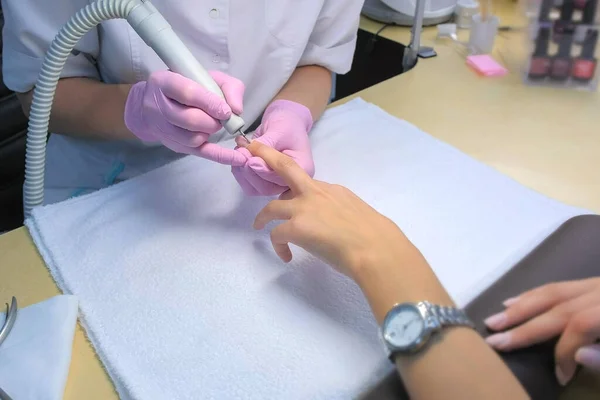 Manicure mestre fazendo manicure para o cliente usando máquina elétrica de broca de unhas. — Fotografia de Stock