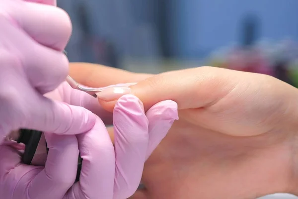 Mestre manicure está cobrindo clientes pintura unhas goma-laca, mãos closeup. — Fotografia de Stock