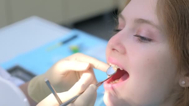 Tandarts orthodontist onderzoekt meisjes tanden met behulp van tandheelkundige hulpmiddelen naald en spiegel. — Stockvideo