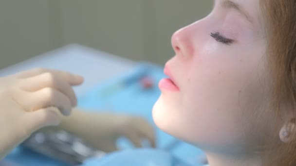 Médico ortodoncista pone frenos transparentes invisibles de silicona en los dientes de las niñas. — Vídeo de stock