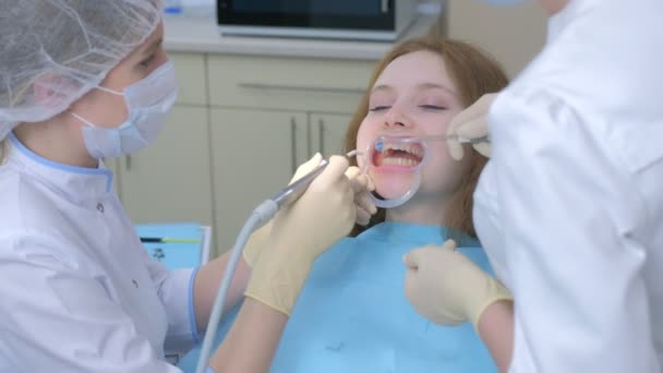 Ασθενής γυναίκα για τον καθαρισμό των δοντιών στην οδοντιατρική από τον οδοντίατρο. — Αρχείο Βίντεο